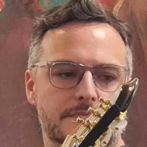 Foto de un hombre de anteojos con guitarra