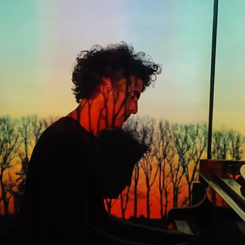 Imagen del pianista durante la función con una imagen detrás del recorrido musicovisual.