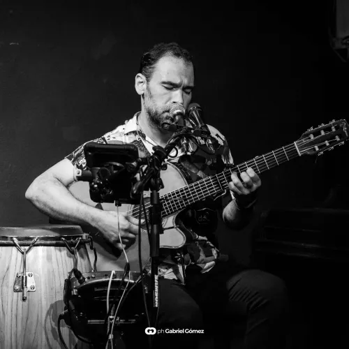 persona tocando la guitarra mirando su instrumento