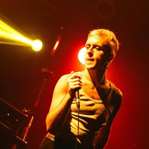 Foto del artista con microfono en mano en show en vivo