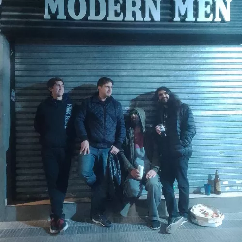 cuatro integrantes de la banda parados adelante de una persiana y arriba de ellos dice "Modern Men"