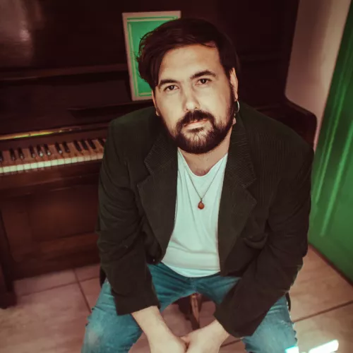 Yo sentado. Atras mio un piano vertical abierto con una partitura en el atril