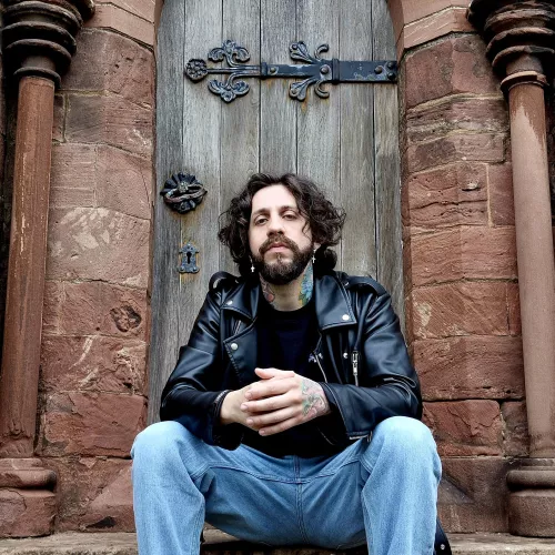 Lautaro Juarez sentado en la puerta de una iglesia/cementerio en el Reino Unido.