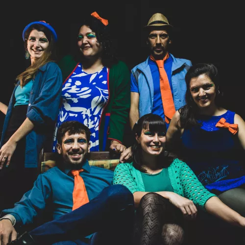 Se visualiza a los integrantes de la banda, seis personas. Cuatro mujeres y dos varones.