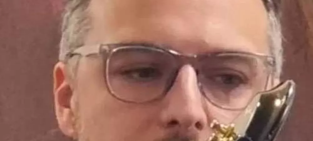 Foto de un hombre de anteojos con guitarra