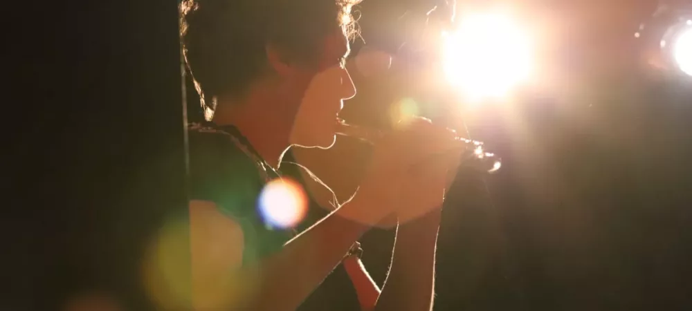 Flautista mujer enfocada por luz escenario