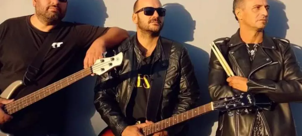 La banda cresta apoyados contra una pared, clásica foto de rock