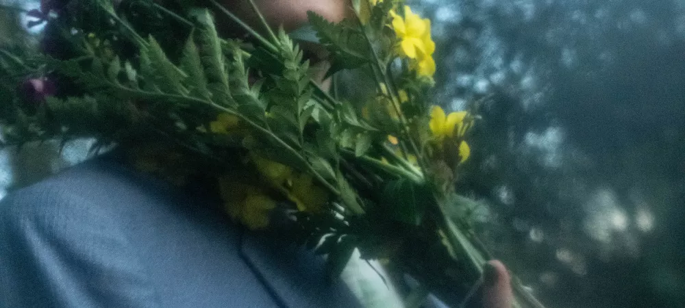 Ine con la cara entre un ramo de flores 