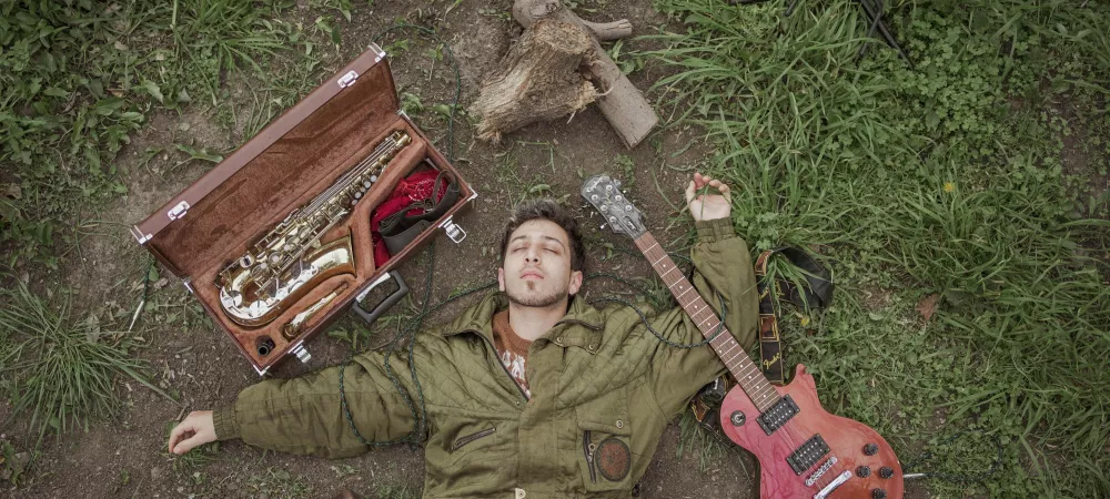 INTI GARCIA con sus instrumentos acostado en la tierra 