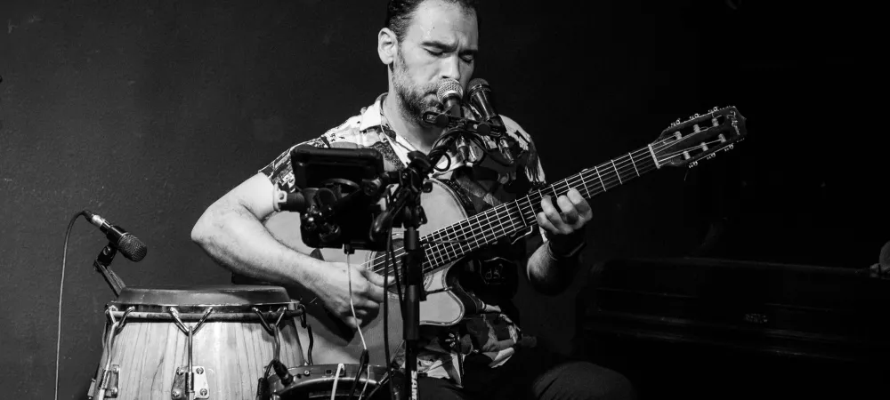 persona tocando la guitarra mirando su instrumento