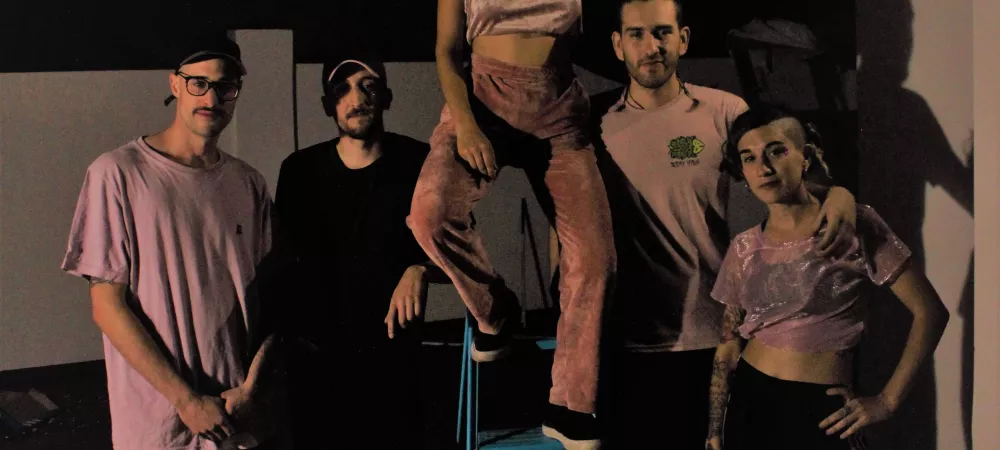los 5 integrantes de la banda posando junto con una escalera