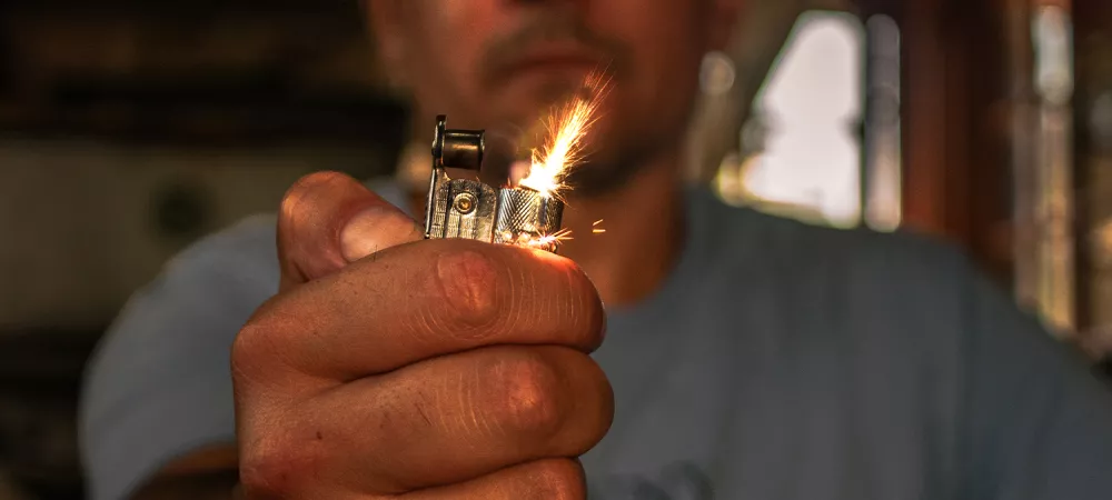 Imagen de frente del artista sosteniendo un encendedor