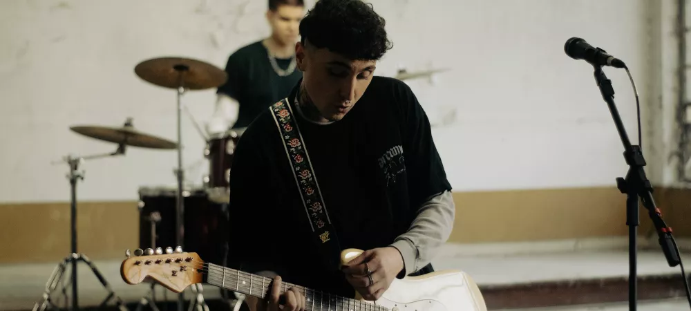 Cabech sosteniendo una guitarra