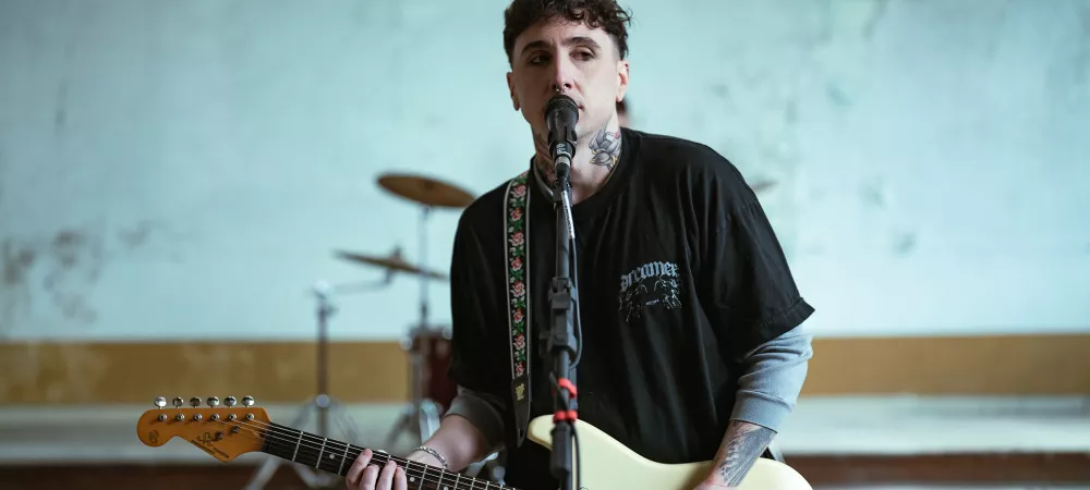 Cabech sosteniendo una guitarra y cantando