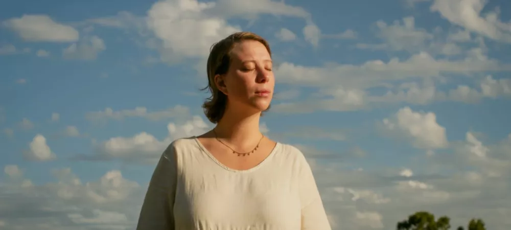 Camila, de blanco, contemplando el sol 