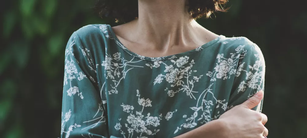 imagen vertical de caro sonriendo con los brazos entrelazados