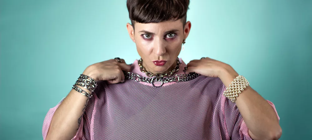 Choco de frente sosteniendo sus collares de cadenas
