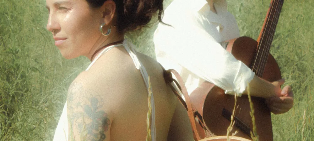 Ambos integrantes del grupo, cada uno mirando a distintos puntos