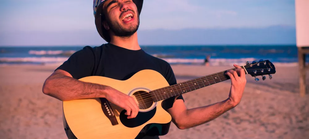 Tocando la guitarra en la playa.