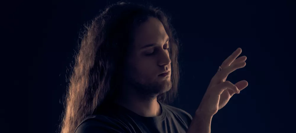 Hombre de pelo largo gestualizando tocar el aire como si fuera un piano