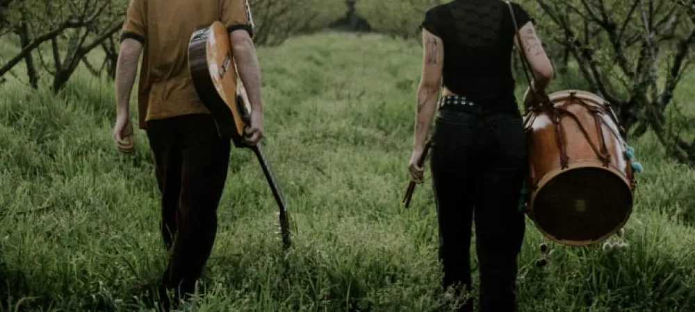 Los integrantes del dúo caminando con sus instrumentos