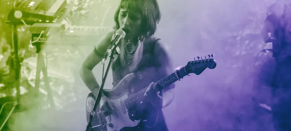 Foto en vivo tocando la guitarra con luces de colores