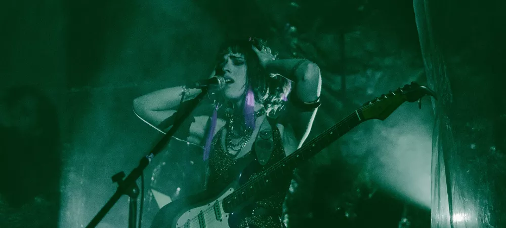 Foto en vivo tocando la guitarra con luces verdes