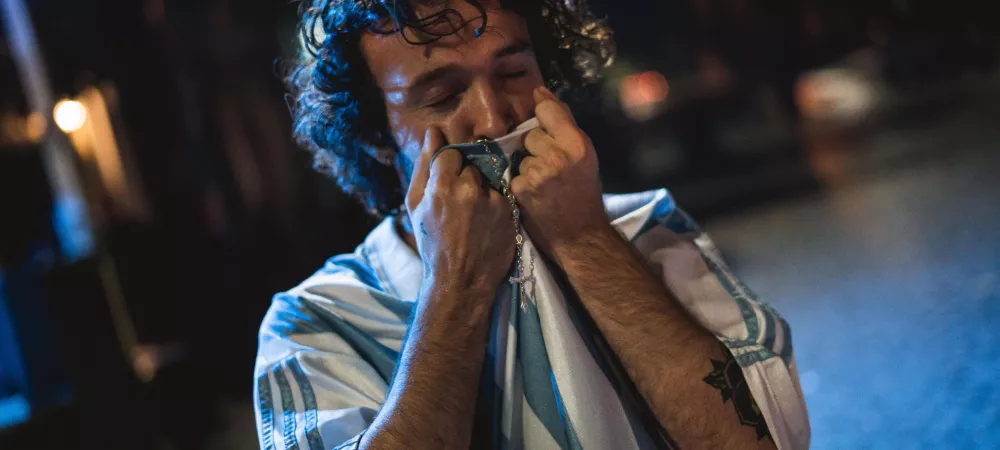 primer plano, foto casual, argentina campeon del mundo besando la remera argentina con detalle de rosario plateado 