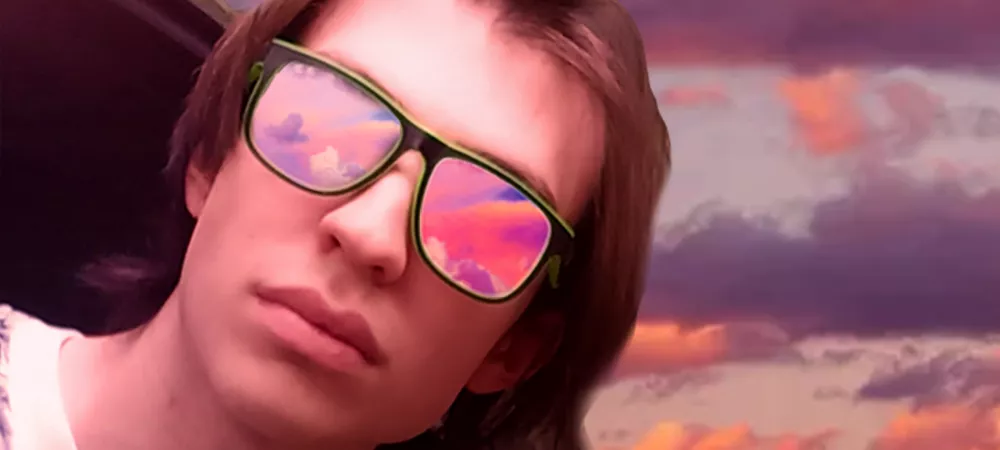 artista figurando en la portada de la canción con anteojos de sol dentro de un auto