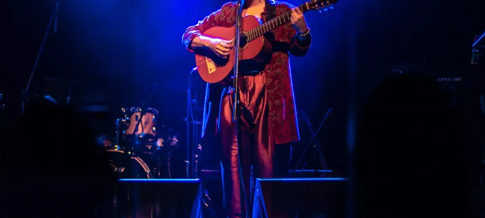 Artista en escenario con iluminación azul
