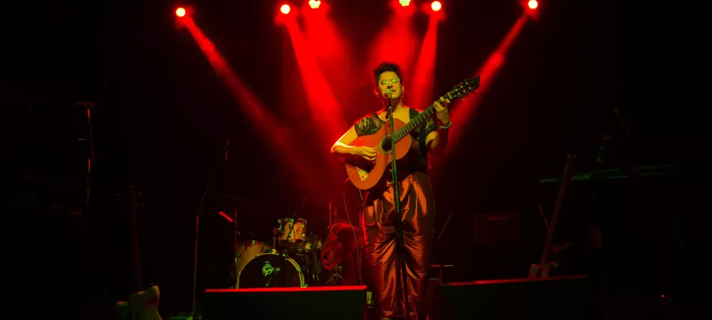 Artista en escenario con iluminación roja