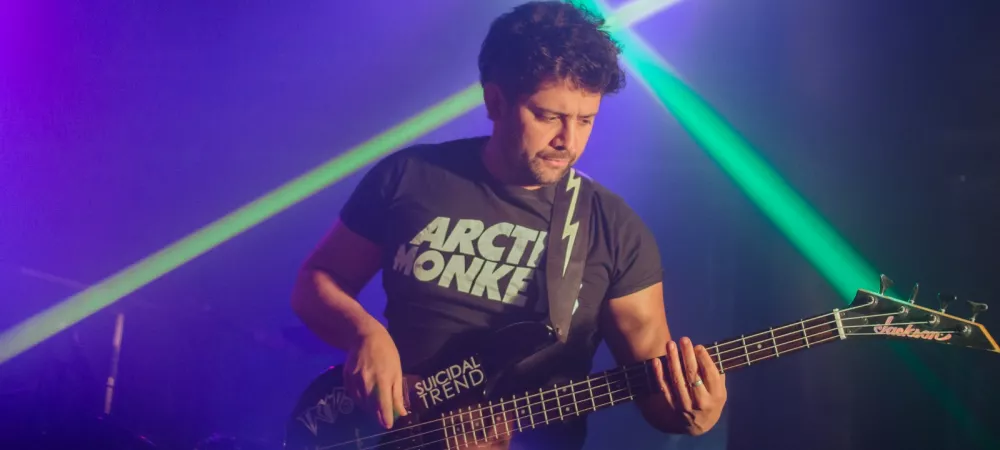 bajista tocando con luces atras