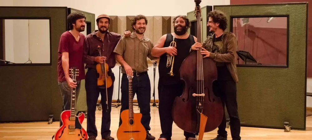 5 músicos de pie en un estudio de grabación