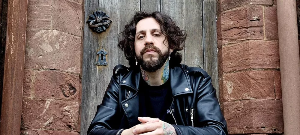 Lautaro Juarez sentado en la puerta de una iglesia/cementerio en el Reino Unido.