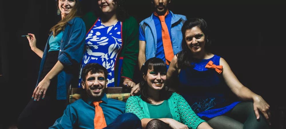 Se visualiza a los integrantes de la banda, seis personas. Cuatro mujeres y dos varones.
