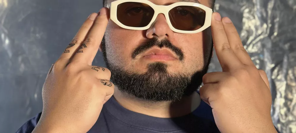 Sando Mic de frente con las manos apoyadas en la cien