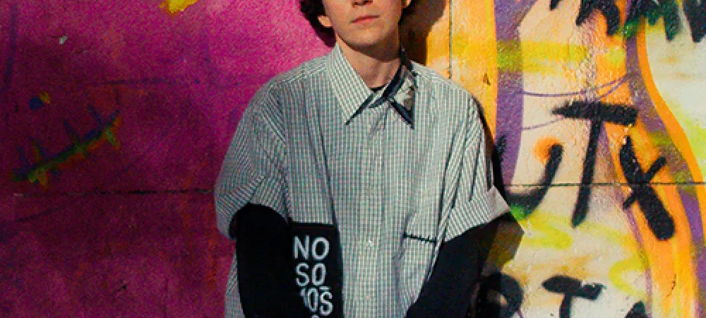 Señorita Novio contra una pared con grafitis de la comunidad queer