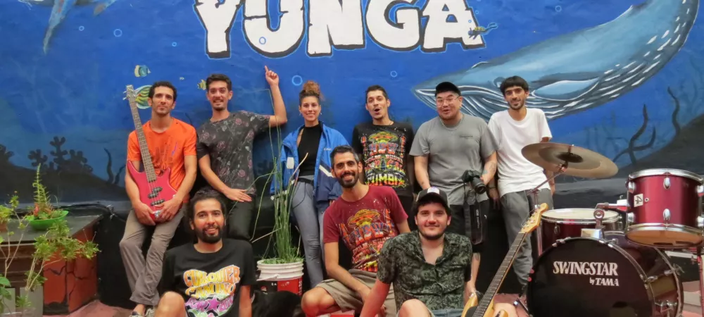 Foto grupal de la banda Yunga junto a colaboradores sobre mural pintado para filmar el videoclip "Limbo"