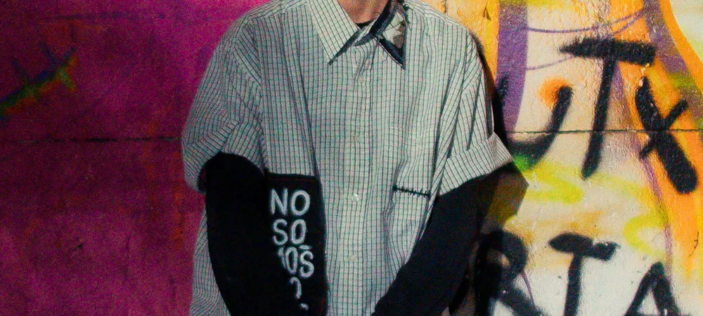 Señorita Novio contra una pared con grafitis de la comunidad queer