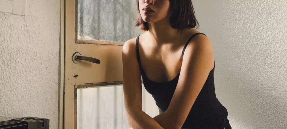 Foto de Valentina sentada frente a una ventana